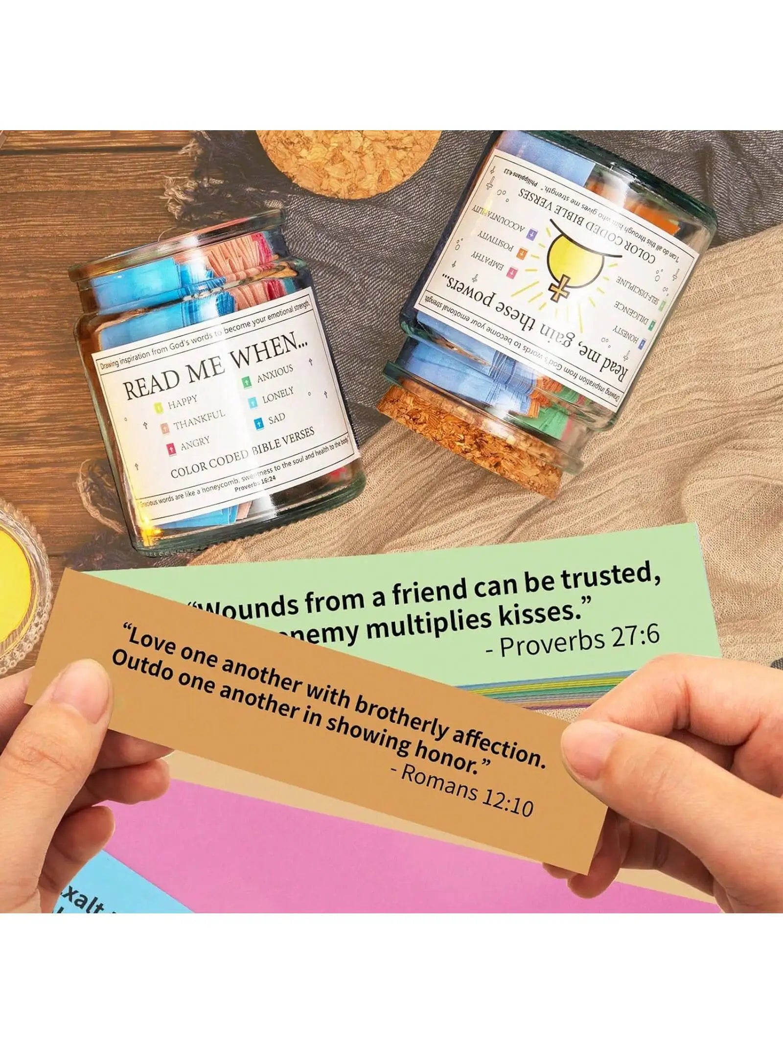 Jars with decorative stones and a card with inspirational quotes on a wooden surface.